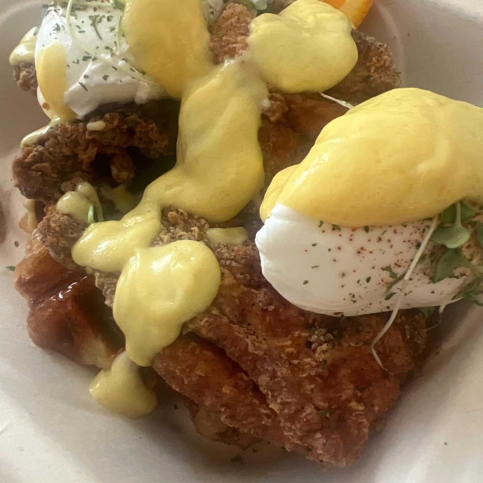 Café Etoile's fried chicken and waffles topped with poached eggs and hollandaise sauce.