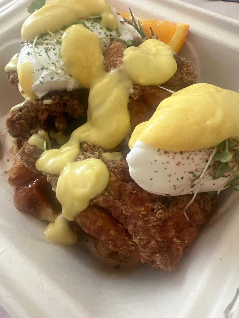 Café Etoile's fried chicken and waffles topped with poached eggs and hollandaise sauce.
